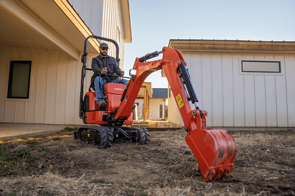 Man digging with compact excavator