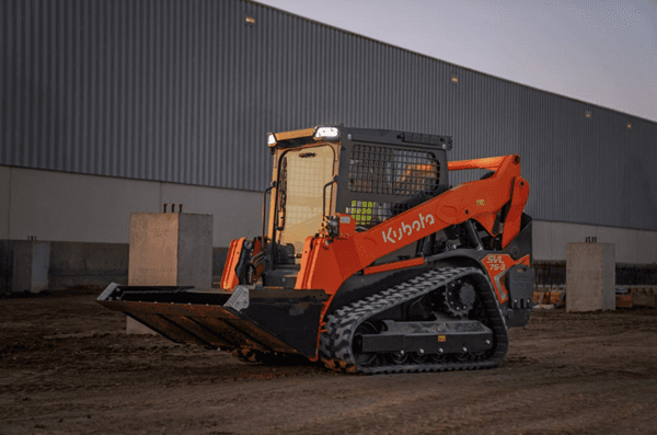 Track Loader staged in front of building