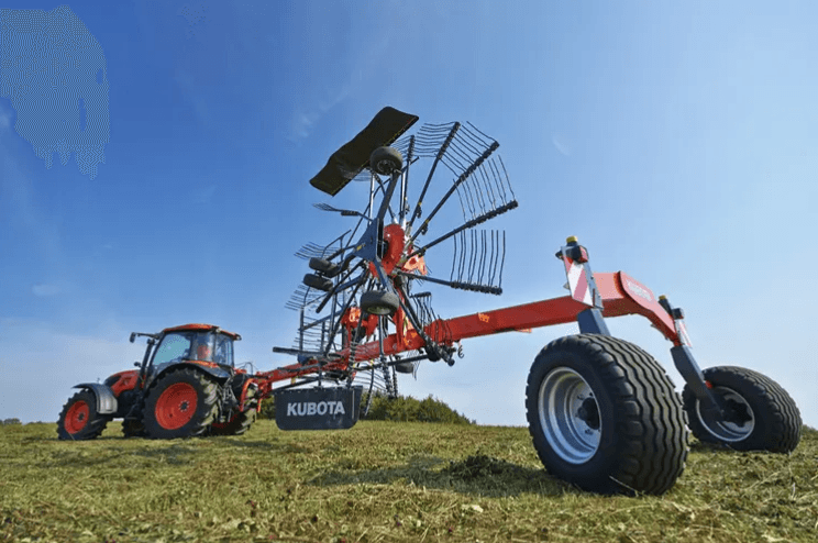 Rotary hay rake hitched onto the back of a tractor