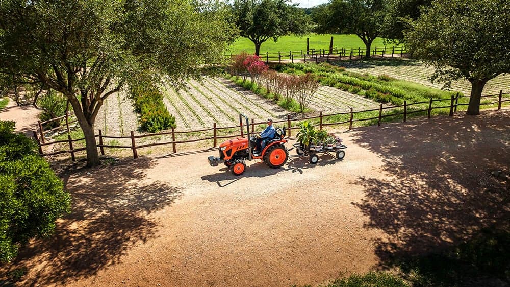Man hauling small trailer with tractor