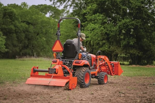 Man using plow implement on tractor