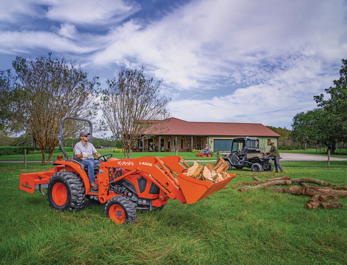 man using kubota tractor with front loader